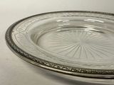 a glass plate with a silver rim on a white table