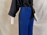 un pantalon bleu et une chemise noire sur un socle de mannequin