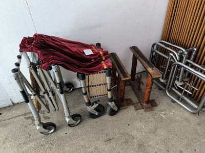 un chariot recouvert d'un tissu rouge, à côté d'un tas d'autres objets