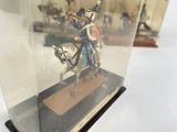 a figurine of a man riding a horse in a glass case