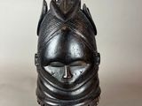 a close up of a black mask on a stand on a white background