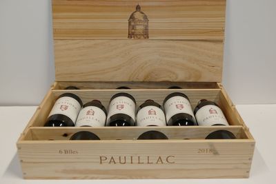 six bouteilles de vin dans un coffret en bois sur une table