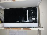 a microwave sitting on top of a shelf in a kitchen
