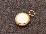 une vieille montre de poche en or, avec une chaîne suspendue sur le côté