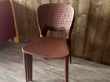 une chaise en plastique marron posée devant un mur en bois