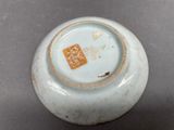 a small white vase with a brown patch in the middle