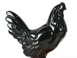 a black and orange rooster statue on an orange base