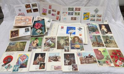 a lot of stamps and postcards on a bed