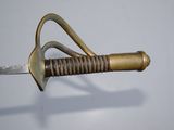 an old sword with a metal handle on a white surface