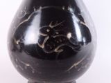 a black vase with gold designs on it on a white background