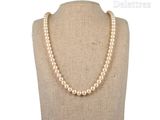 pearl necklace on a mannequin display with a white background