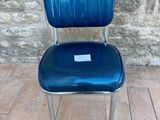 a blue chair that is sitting in front of a stone wall