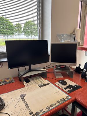 a desk with two computer monitors and a phone on it