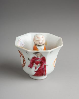 une petite tasse contenant une figurine