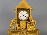 a gold clock sitting on top of a wooden table