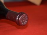 a bottle of wine that is on a red table