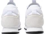 the white sneakers are on a white surface with black soles