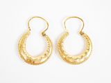 une paire de boucles d'oreilles en or sur fond blanc