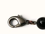an image of a close up of a keychain with a black bead