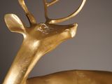 a close up of a gold statue of a deer