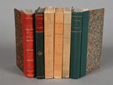 several old books are stacked on top of each other on a table