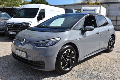 La voiture grise est garée sur le parking, à côté d'autres voitures.