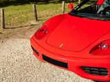 a red sports car parked on a gravel road