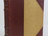 an old book with a brown cover sitting on top of a white table