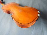 a close up of a violin on a table with a gray background