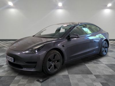 the tesla model 3 is parked on a checkered tile floor