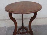 a small table with a wooden top on a cement floor