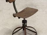 a wooden chair that is sitting on top of a metal stool