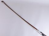 an old violin bow with a wooden handle on a white surface