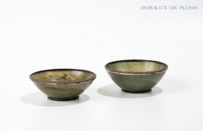 two bowls sitting on a white surface with a white background