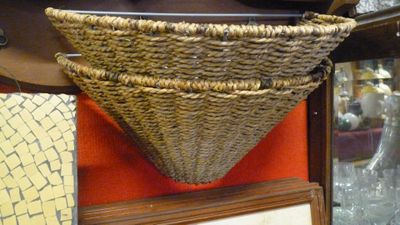 un panier en osier accroché au mur à côté d'un cadre photo