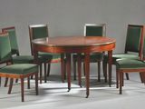 quatre chaises disposées autour d'une table à manger ronde, avec un coussin vert
