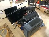 two monitors and a laptop sitting on top of a pile of electronics