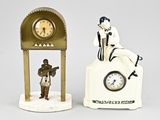 deux figurines représentant des personnes assises au sommet d'une horloge