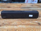 a black speaker sitting on top of a wooden table
