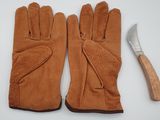 deux paires de gants et un marteau posés sur une surface blanche
