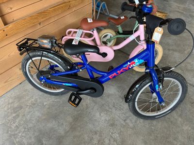 un vélo bleu avec une selle rose et un panier à l'arrière