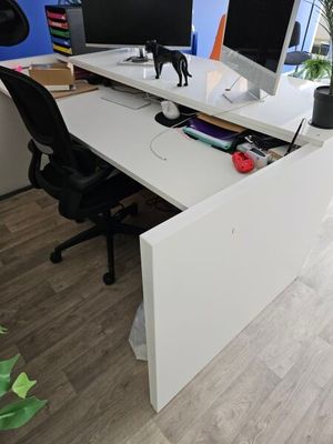 a desk with two monitors and a keyboard on it
