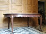 une grande table en bois dans une pièce au sol carrelé