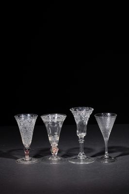 four wine glasses sitting on top of a table next to each other