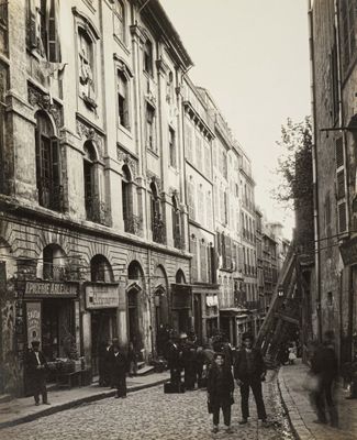 a black and white photo of people walking down the street