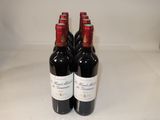 three bottles of red wine sitting on a table