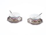 two bowls and spoons sitting on top of each other