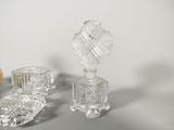 three pieces of glass sitting on a table with a clock in the background