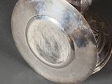 a silver vase with a silver lid on a table