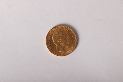 une pièce d'or sur une surface blanche avec un fond blanc